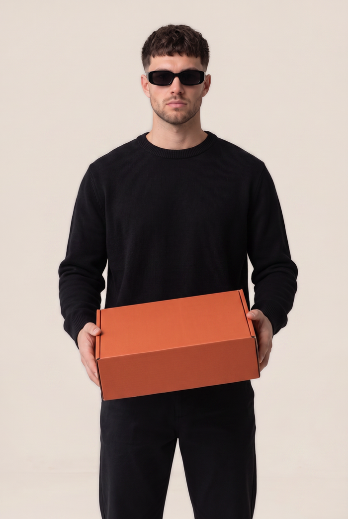 Skrivnostna škatla Creed Fashion — model drži paket s puloverji